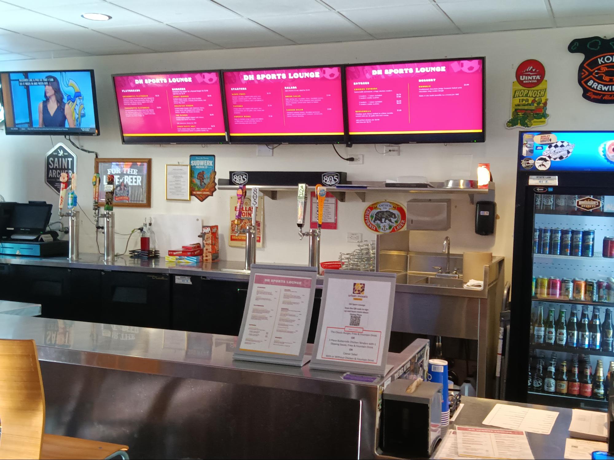 Photo of deli counter with pink digital signs.