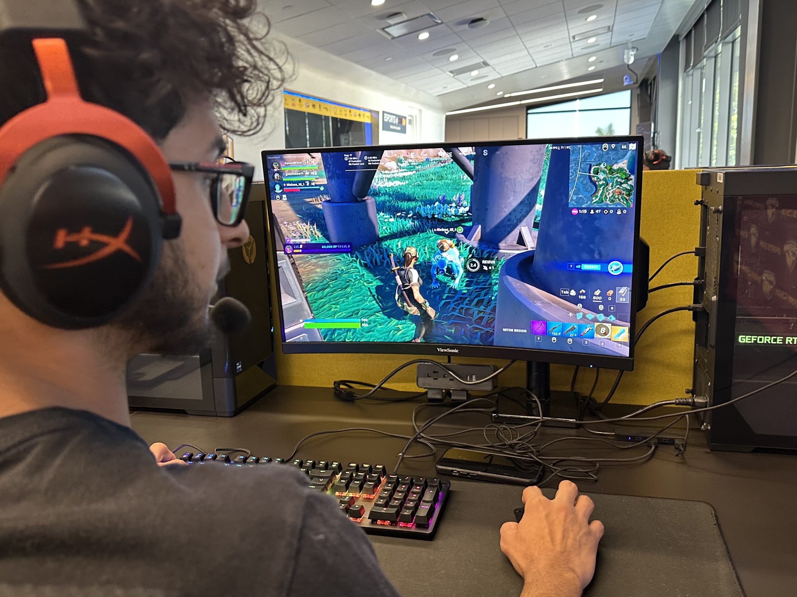 Photo of person with glasses and headphones playing a computer game.