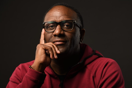 Portrait photo of a man with glasses and red hoodie.
