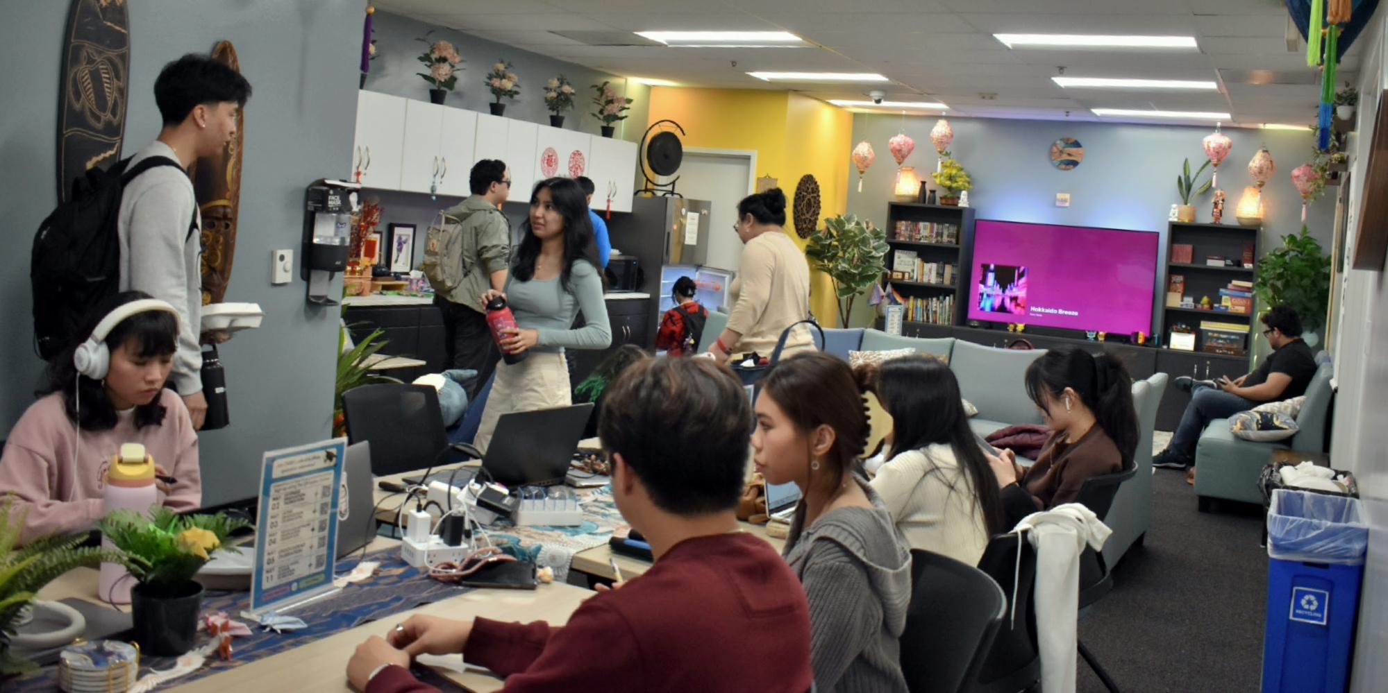 Photo of a college space with lots of students seated and standing.