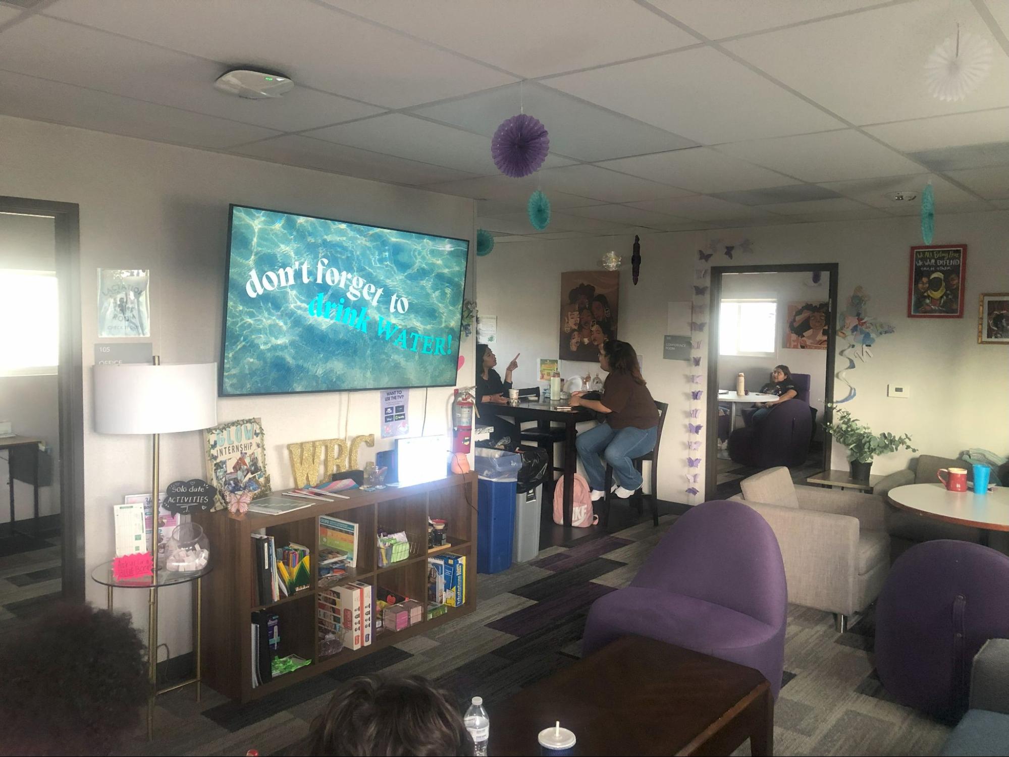 Photo of a room with "Don't forget to drink water" displayed on a screen.