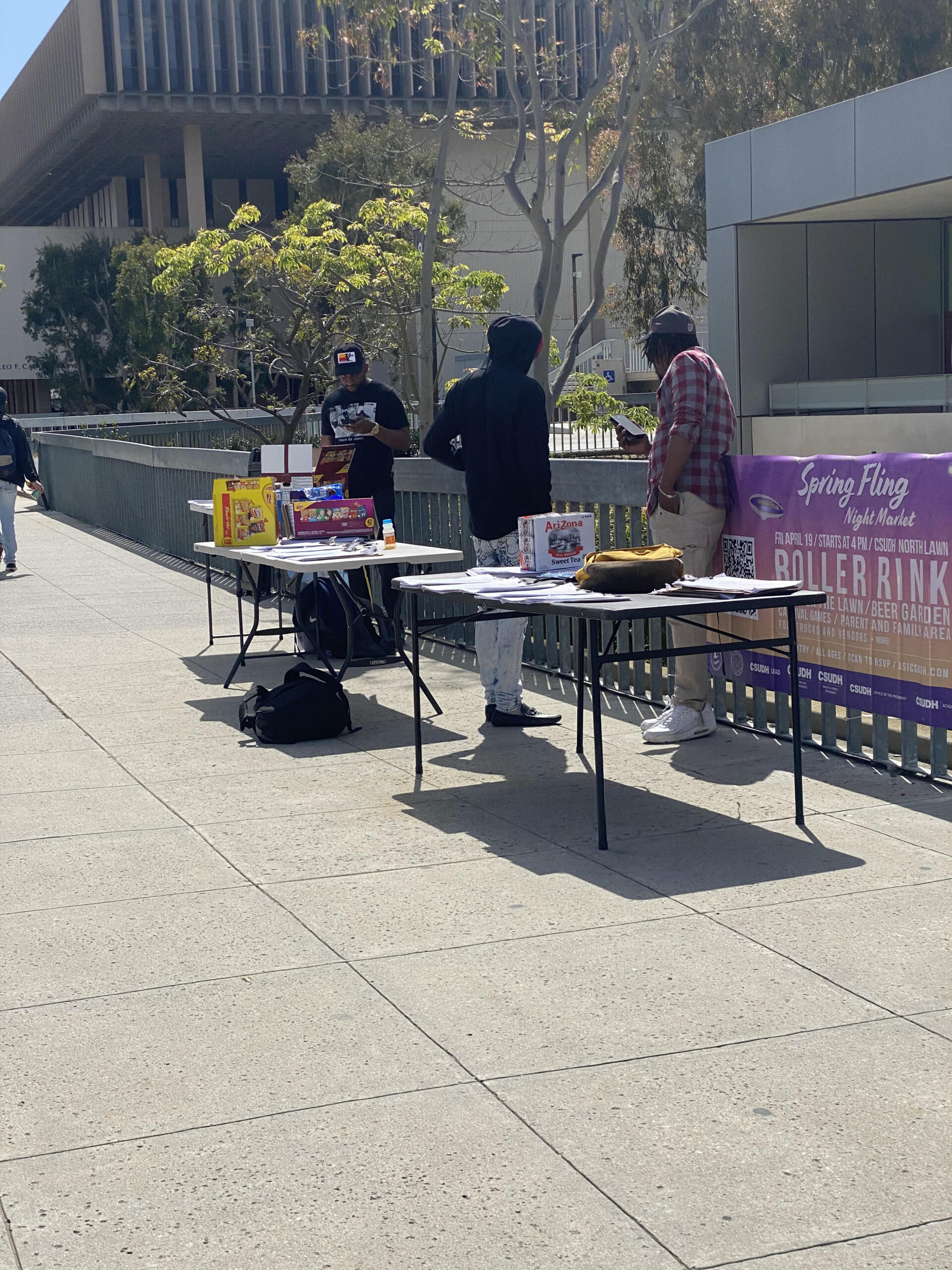 Photo of tables with two people behind them.