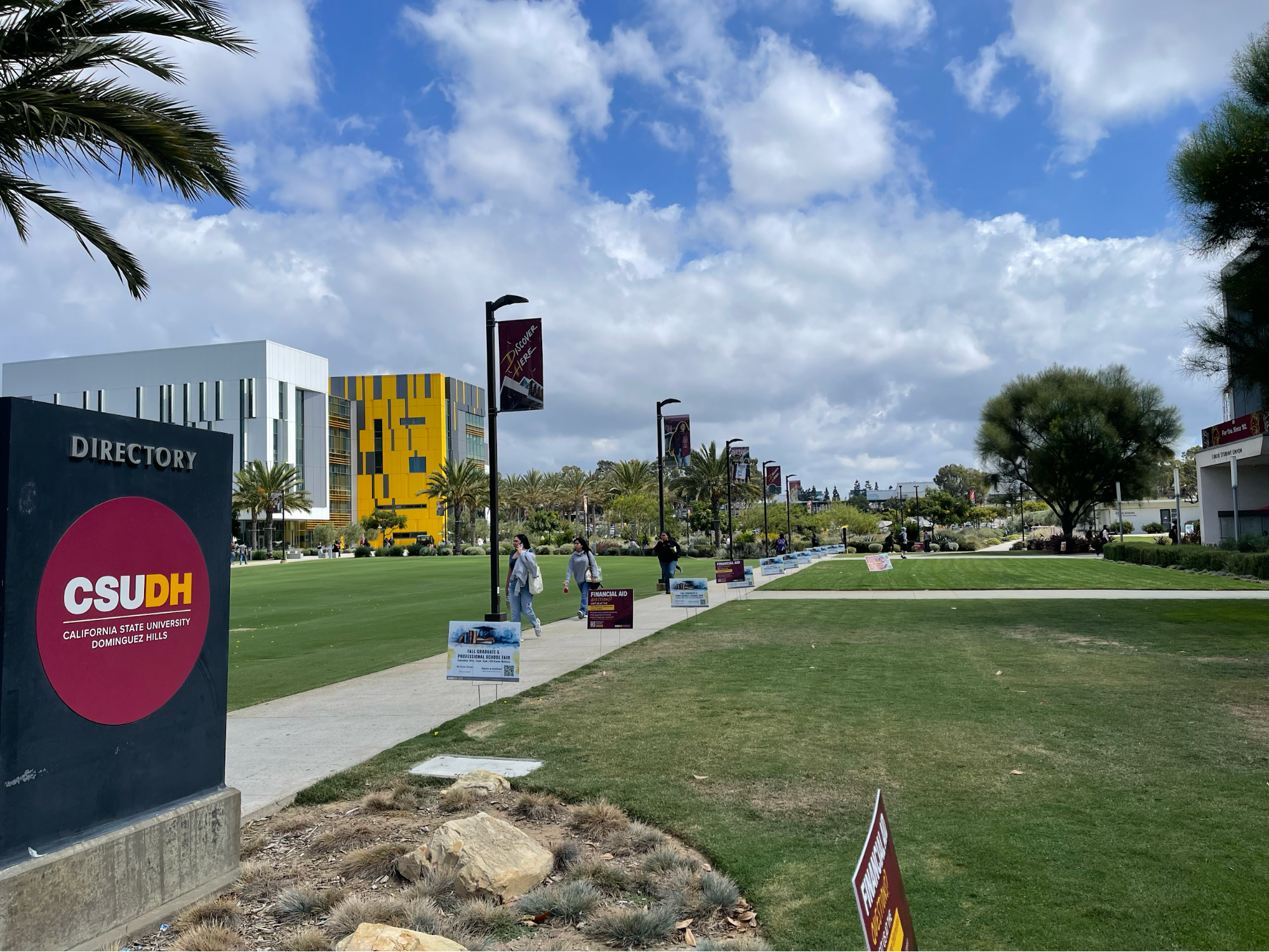 Photo of green lawn area on campus with sky.