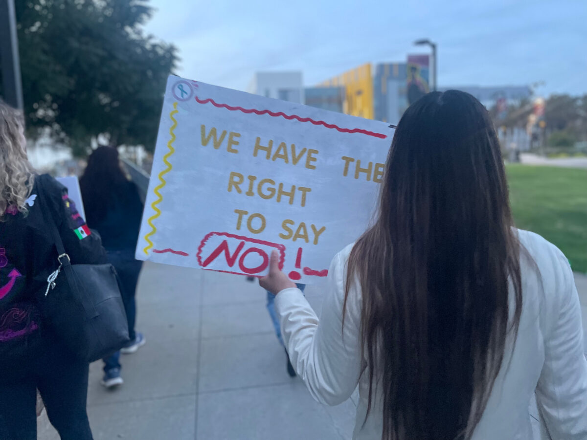 A student holds a sign reading "We have the right to say 'No'!" during a Take Back the Night campus march.