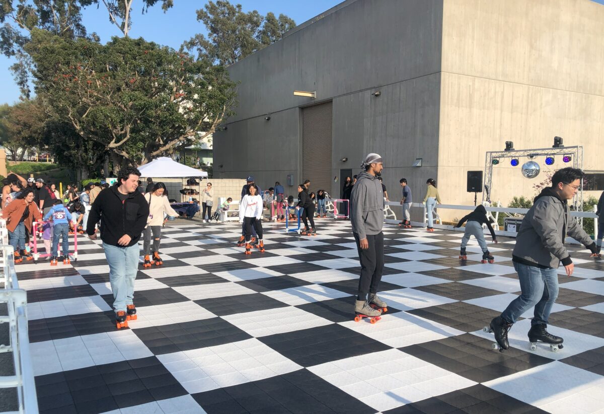 Students skate on a checkered outdoor rink during a campus night market event